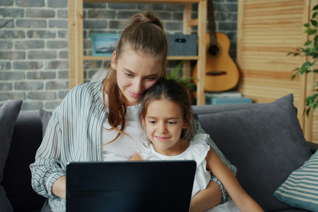 A mother and daughter looking at a laptop together
