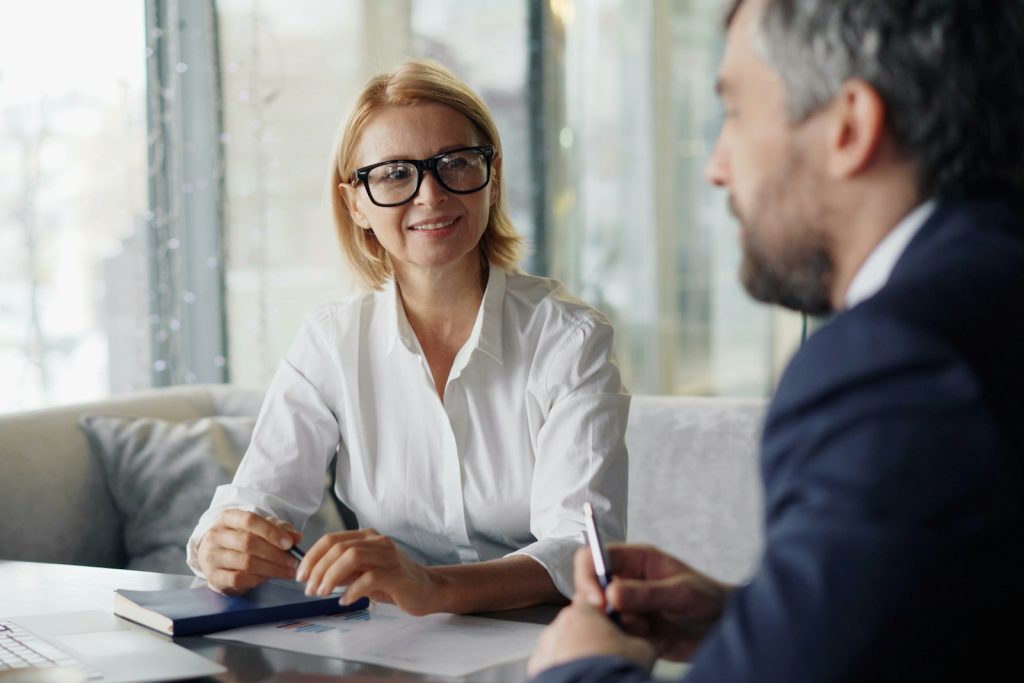 Two people talking across a table in an office