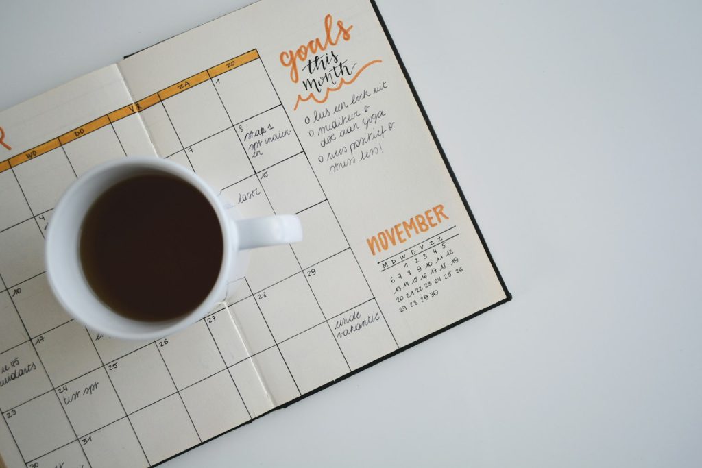 A cup of coffee on an open monthly planner